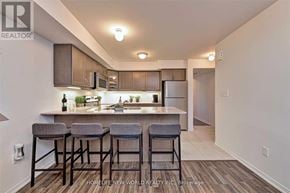 Oakville (Ro River Oaks) townhouse for rent - A kitchen with bar stools in front of it.