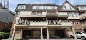 Mississauga (Cooksville) townhouse for rent - A large, multi-level residential building with balconies and garages.