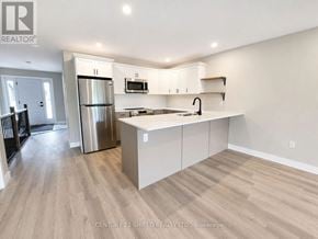 South Stormont townhouse for rent - A kitchen with white cabinets and a stainless steel refrigerator.