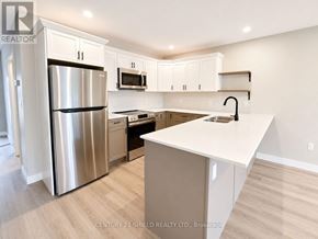 South Stormont townhouse for rent - A kitchen with white cabinets and a stainless steel refrigerator.