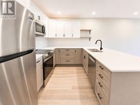 South Stormont townhouse for rent - A modern kitchen with wooden floors and stainless steel appliances.
