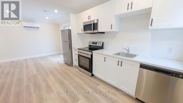 St. Catharines (Grapeview) apartment for rent - A kitchen with white cabinets and a wooden floor.