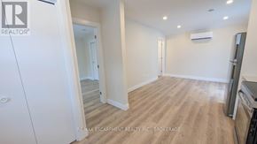 St. Catharines (Grapeview) apartment for rent - A white refrigerator is in the corner of a room with wood flooring and white walls.
