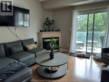 Windsor condo for rent - A living room with a grey couch and a fireplace.