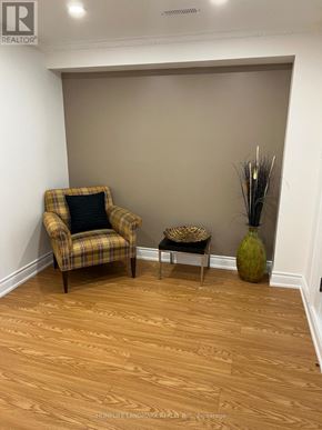 Vaughan (Patterson) apartment for rent - A room with a chair and a table with a vase on it.