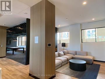 Vaughan (Beverley Glen) condo for rent - A modern living room with a large sectional sofa and a wooden floor.