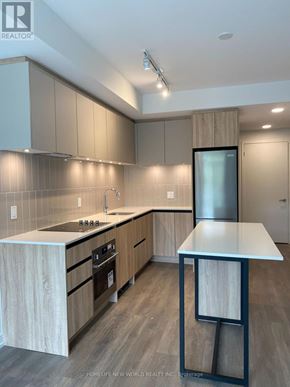 Vaughan (Beverley Glen) condo for rent - A modern kitchen with wooden cabinets and a white countertop.