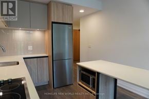 Vaughan (Beverley Glen) condo for rent - A modern kitchen with a stainless steel refrigerator and white countertops.