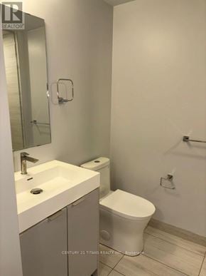 Vaughan (Concord) condo for rent - A white toilet sits next to a sink in a bathroom.