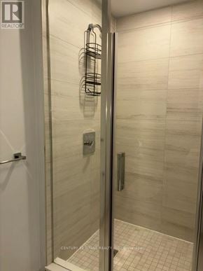Vaughan (Concord) condo for rent - A glass shower door with a metal rack on the wall.