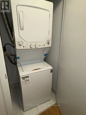 Vaughan (Concord) condo for rent - A white dryer is in a small room with a label that says Century 21.