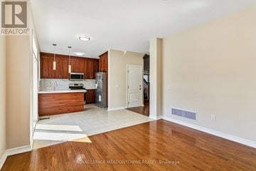 Caledon apartment for rent - A kitchen with wooden cabinets and a white refrigerator is shown.