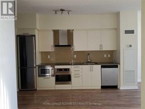 Toronto (Waterfront Communities) condo for rent - A kitchen with white cabinets and a tiled backsplash.