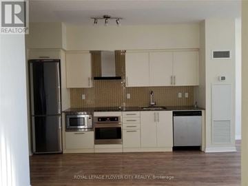 Toronto (Waterfront Communities) condo for rent - A kitchen with white cabinets and a tiled backsplash.