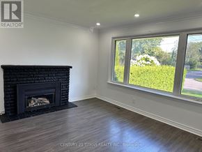 Toronto (Rouge) apartment for rent - A room with a fireplace and a window overlooking a green area.