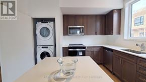 Newmarket (Glenway Estates) townhouse for rent - A realtor photo of a kitchen with brown cabinets and a white counter.
