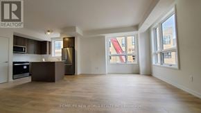 Newmarket (Glenway Estates) townhouse for rent - A spacious living room with a kitchen area in the background.
