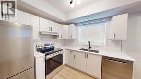 Grande Prairie apartment for rent - A modern kitchen with white cabinets and a stainless steel refrigerator.