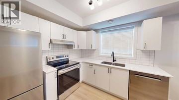Grande Prairie apartment for rent - A modern kitchen with white cabinets and a stainless steel refrigerator.
