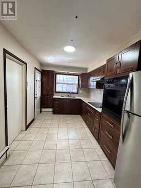 Toronto (Highland Creek) apartment for rent - A kitchen with white appliances and brown cabinets.