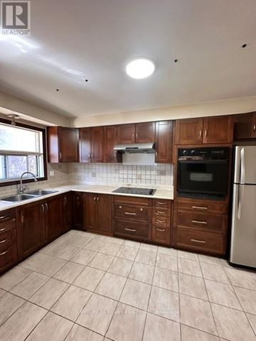 Toronto (Highland Creek) apartment for rent - A kitchen with brown cabinets and a white fridge.
