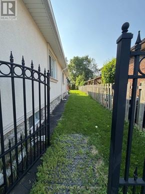Mississauga (Mineola) apartment for rent - A black iron fence runs along the side of a white house.
