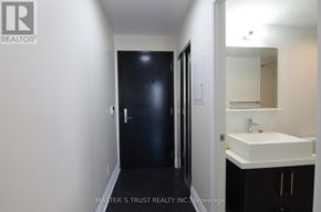 Toronto (Bay Street Corridor) condo for rent - A bathroom with a sink, mirror, and a black door.