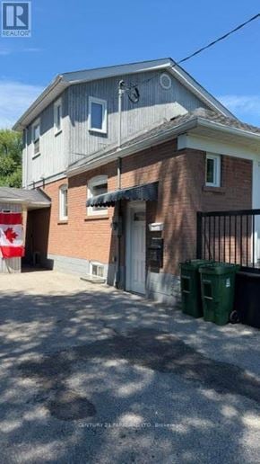 Toronto (Cliffcrest) apartment for rent - A two-story building with a garage door and a Canadian flag in the background.