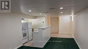 Toronto (Cliffcrest) apartment for rent - A realtor photo of a kitchen with white appliances and a green floor.