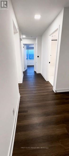 Toronto (North St. James Town) condo for rent - A long hallway with wooden floors and white walls.