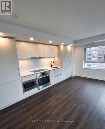 Toronto (North St. James Town) condo for rent - A kitchen with white cabinets and a stainless steel island.