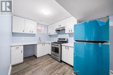 Brampton (Sandringham-Wellington) apartment for rent - A kitchen with white cabinets and a blue fridge.