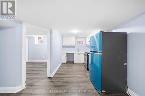 Brampton (Sandringham-Wellington) apartment for rent - A kitchen with a blue fridge and white cabinets.