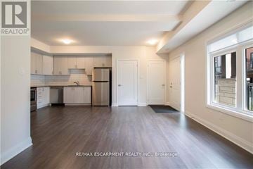 Brant (Paris) townhouse for rent - A spacious kitchen with white cabinets and a refrigerator.