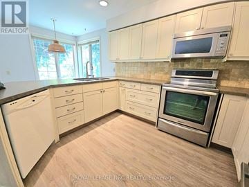 St. Catharines (Glendale/Glenridge) apartment for rent - A kitchen with wooden cabinets and a stainless steel oven.