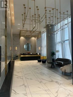 Vaughan (Vaughan Corporate Centre) condo for rent - A reception area with a black counter and a large mirror.