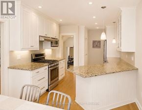 Mississauga (Port Credit) apartment for rent - A kitchen with white cabinets and a granite countertop.