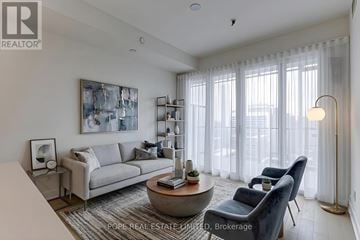 Toronto (Bay Street Corridor) condo for rent - A living room with a grey couch, a coffee table, and a large painting on the wall.