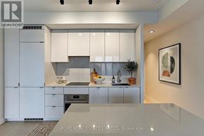 Toronto (Bay Street Corridor) condo for rent - A modern kitchen with white cabinets and a glass backsplash.