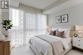 Toronto (Bay Street Corridor) condo for rent - A bedroom with a large bed, a nightstand, and a plant.