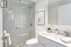 Toronto (Bay Street Corridor) condo for rent - A modern bathroom with a glass shower stall and a white sink.