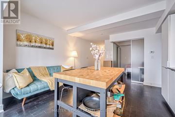 Toronto (Bay Street Corridor) condo for rent - A living room with a couch, a table, and a painting on the wall.