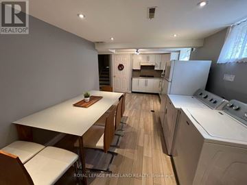 Toronto (Bayview Woods-Steeles) apartment for rent - A kitchen with a table and chairs in the foreground and a refrigerator in the background.