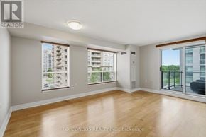 Toronto (Willowdale East) condo for rent - A spacious room with wooden flooring and large windows.