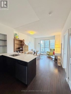 Toronto (Church-Yonge Corridor) condo for rent - A modern kitchen with dark wood floors and white countertops.