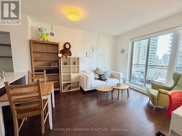 Toronto (Church-Yonge Corridor) condo for rent - A living room with a white couch and a wooden chair.