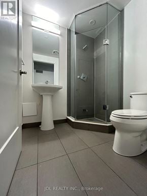 Toronto (Waterfront Communities) condo for rent - A white toilet sits next to a walk-in shower in a bathroom.
