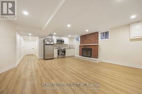 Toronto (Tam O'shanter-Sullivan) apartment for rent - A spacious living room with a fireplace and a kitchen area in the background.