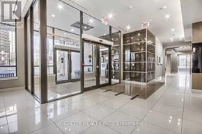 Toronto (York University Heights) condo for rent - The image shows the interior of a modern building with glass doors and windows, and a sign that reads "BIG CITY REALTY INC. Brokerage".