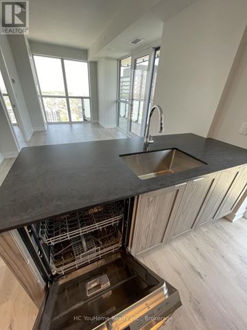 Mississauga (City Centre) condo for rent - A modern kitchen with a sink and a dishwasher.